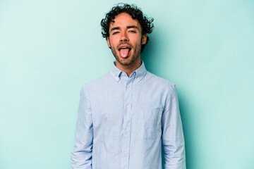Young caucasian man isolated on white background funny and friendly sticking out tongue.