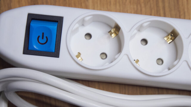 White extension cord with sockets and blue power button.