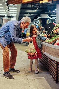 Child And Her Grandfather In Grocery Store