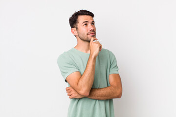 young handsome hicpanic man feeling thoughtful, wondering or imagining ideas, daydreaming and...