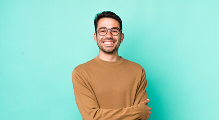 young handsome hicpanic man laughing shyly and cheerfully, with a friendly and positive but insecure attitude