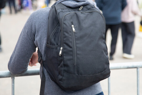 A black satchel, a bag for carrying things on a man.
