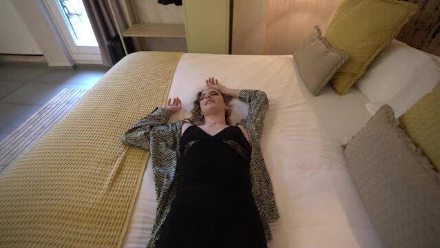 Chica joven delgada tumb&aacute;ndose en habitaci&oacute;n de un hotel