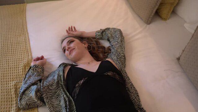 Chica joven delgada tumb&aacute;ndose en habitaci&oacute;n de un hotel