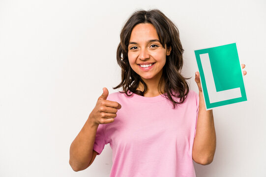 Young hispanic woman holding a beginner driver sign isolated on white background smiling and raising thumb up