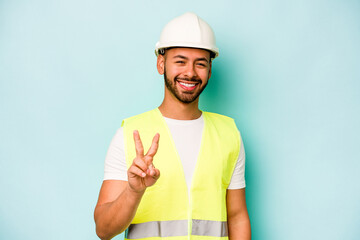 Young laborer hispanic man isolated on blue background showing number two with fingers.
