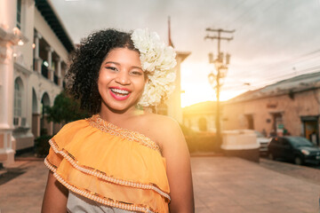 Traditional dance dancer from Nicaragua mestizo with curly hair smiling and looking at the camera at sunset wearing the typical dress of Central America - obrazy, fototapety, plakaty
