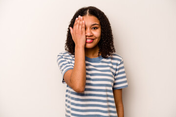 Young African American woman isolated on white background having fun covering half of face with palm.