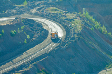 The process of irrigating a technical road with an irrigation automobile. The irrigation vehicle on the basis of a large quarry truck in operation. Dust suppression in a mining quarry.