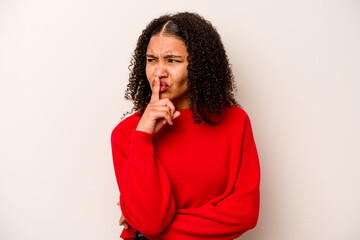 Young African American woman isolated on white background keeping a secret or asking for silence.