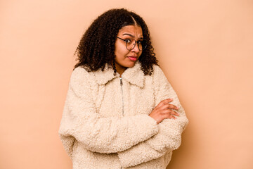 Young African American woman isolated on beige background unhappy looking in camera with sarcastic expression.