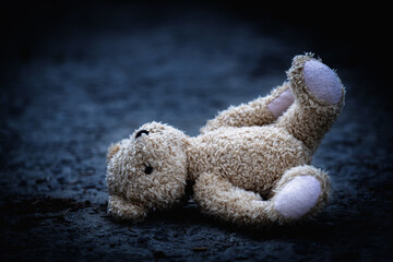 Lost childhood, war and loneliness. Conceptual picture of a children's toy teddy bear. Horizontal image.