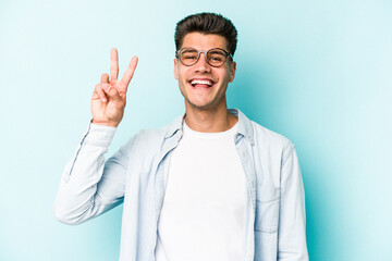 Young caucasian man isolated on blue background showing number two with fingers.