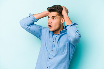 Young caucasian man isolated on blue background screaming, very excited, passionate, satisfied with something.