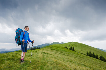 Naklejka na ściany i meble Hiking man walking in the mountains