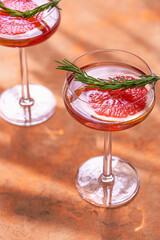 Summer refreshing  grapefruit cocktail with  rosemary and ice. Cold lemonade. Selective focus.