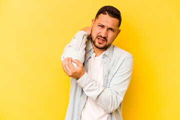 Young hispanic man isolated on yellow background having a neck pain due to stress, massaging and touching it with hand.