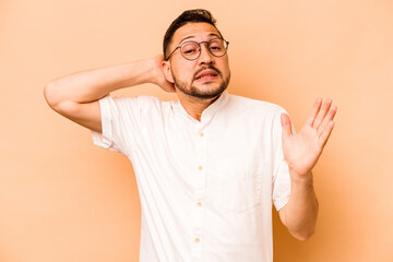 Young hispanic man isolated on beige background screaming with rage.