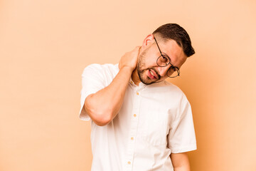 Young hispanic man isolated on beige background suffering neck pain due to sedentary lifestyle.