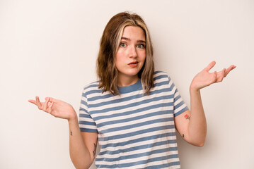 Young caucasian woman isolated on white background doubting and shrugging shoulders in questioning gesture.