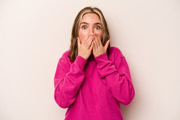 Young caucasian woman isolated on white background shocked, covering mouth with hands, anxious to discover something new.