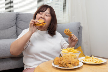 Overweight Woman Enjoy Eatting Beef Burger with Fried Drumstick Chicken