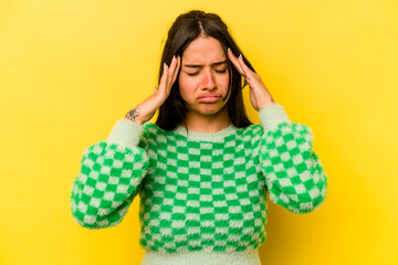 Young hispanic woman isolated on yellow background touching temples and having headache.