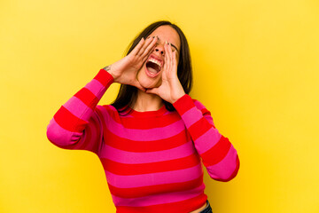 Young hispanic woman isolated on yellow background shouting excited to front.