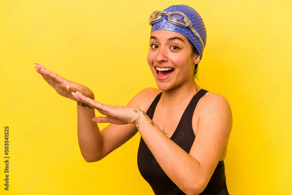 Wall mural Young swimmer hispanic woman isolated on yellow background - Wall murals