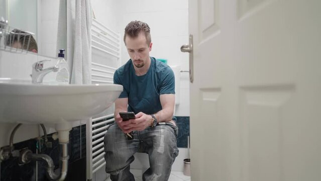 Man in bathroom caught using smartphone addiction while on toilet 4K