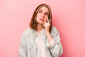 Young caucasian woman isolated on pink background crying, unhappy with something, agony and confusion concept.