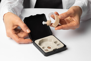Hearing aid in a box in the hands of a doctor.
