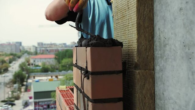 bricklayer lays bricks, exterior wall