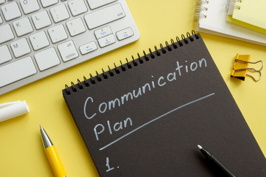 Communication plan on the open black notebook.