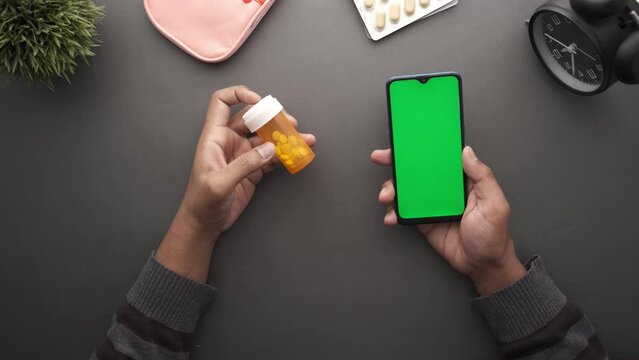 young man hand holding medicine pill container and smart phone 