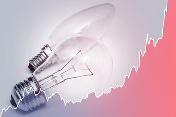 Light bulbs and rising chart representing current electricity price during energy crisis in the...