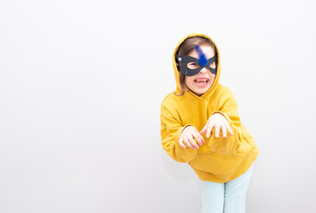 A 6-year-old girl emotionally imitates a cat, emotions on her face, hisses. Gray background and...
