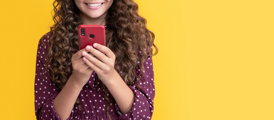 cheerful kid with curly hair chatting on phone on yellow background