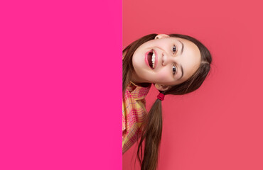 happy girl behind blank pink paper with copy space for advertisement