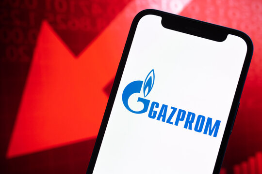 Gazprom oil prices, logo close-up. Collapse, petroleum crisis, red arrow down on stock market graphs background photo