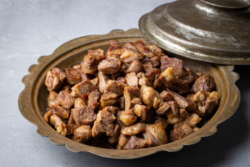 Muslims Traditional Sacrifice holiday food lamb, Turkish roasted meat in copper pot on table top. Turkish Kavurma. (Turkish name; Kurban kavurma)