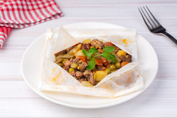Traditional Turkish food; Meat with vegetables wrapped in greaseproof paper, kebab (Turkish name; Sebzeli kagit kebabi)