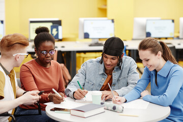 Vibrant shot of diverse group of young people studying together at table in college lab