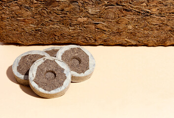 Coconut fiber and round peat briquettes on a beige background. gardening, shadow