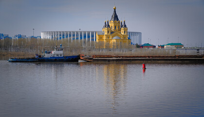 A river tug pushes a barge. Red floating signal buoy to determine the fairway. The beginning of navigation on the big river.