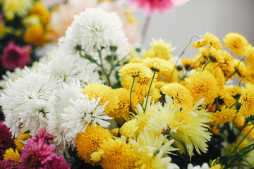 Beautiful autumn flowers close up in rustic room. Hello autumn! Floral wallpaper. Stylish fall bouquets with yellow and pink asters and dahlias. Happy Thanksgiving! Moody image