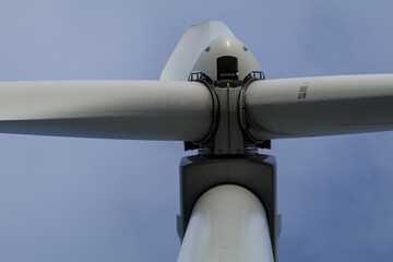 Nahaufnahme der Nabe einer Windkraftanlage vor blauem Himmel