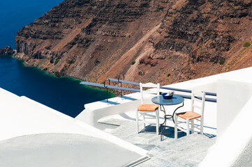 White architecture on Santorini island, Greece. Two chairs on the terrace with sea view. Travel and summer vacations concept