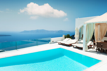 White architecture on Santorini island, Greece. Luxury swimming pool with sea view. Travel and summer vacations concept
