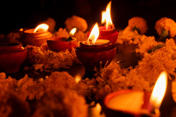 Very low angle view of Rangoli flowers and candles or diyas, Deepawali lights at night. Dark background stock image.